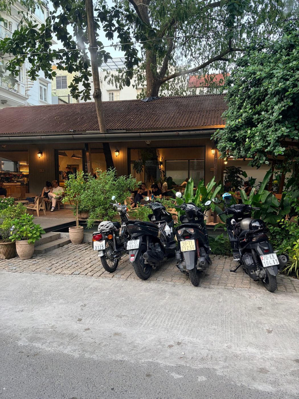 Motorbikes parked outside a leafy café where locals work and chat